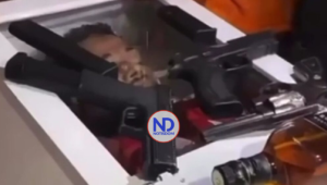 Velan restos de un joven exhibiendo armas de fuego y bebidas encima del ataúd