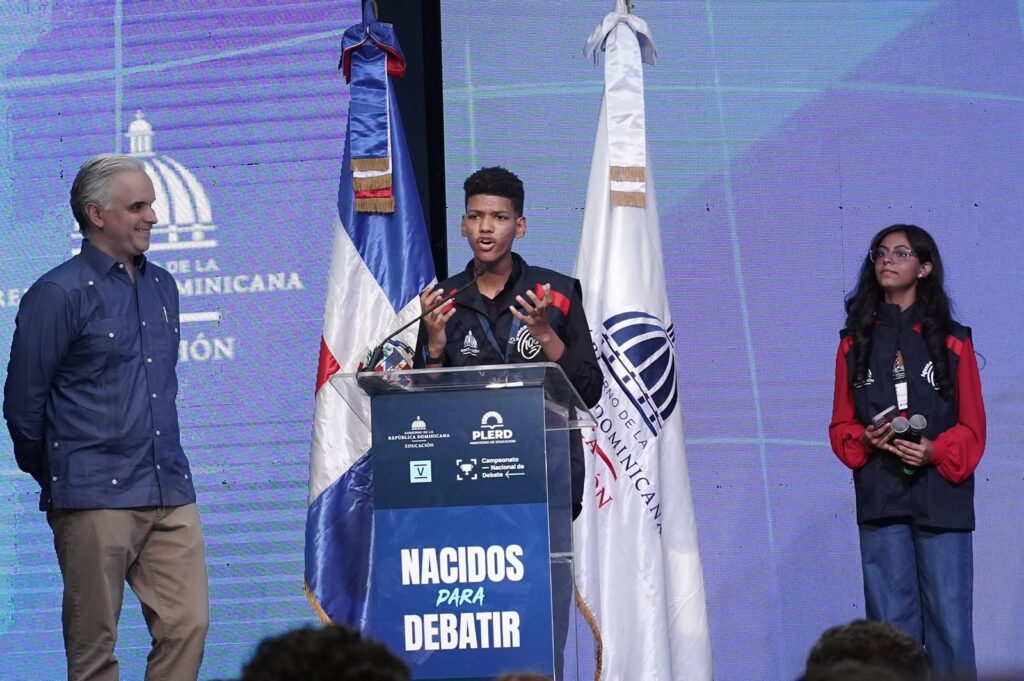 Luis Miguel De Camps mientras observa estudiantes en turno de debate Luis Miguel De Camps resalta el debate escolar como herramienta para fortalecer el pensamiento crítico